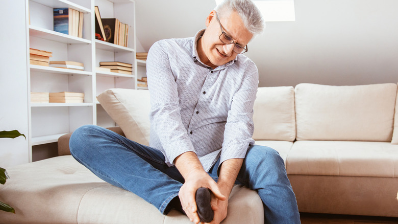 A person over 50 experiencing numb toes while sitting