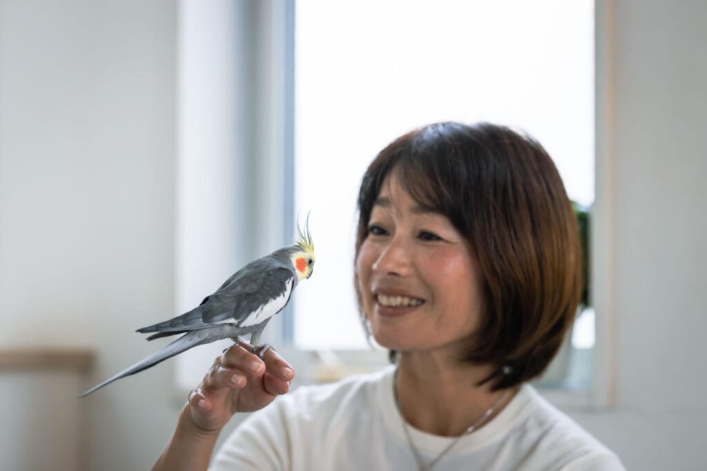 older adult enjoying pet bird at home calm companionship after 50