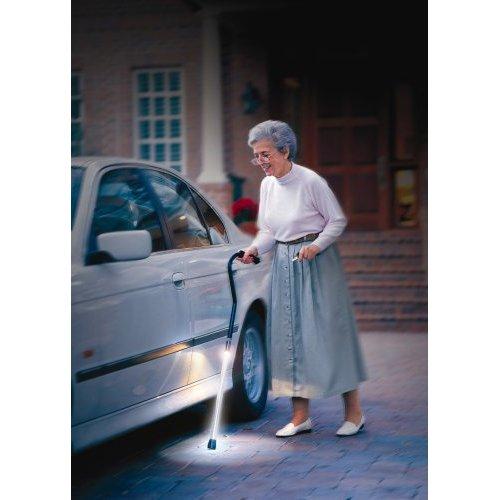 Senior using a walking cane with a built-in light during an evening walk