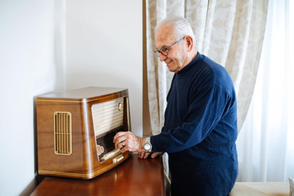 An older man or woman sitting comfortably, listening to music and reliving back memories