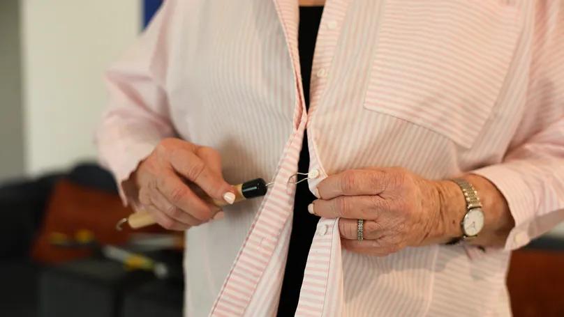 Button hooks and zipper pulls helping a senior dress independently